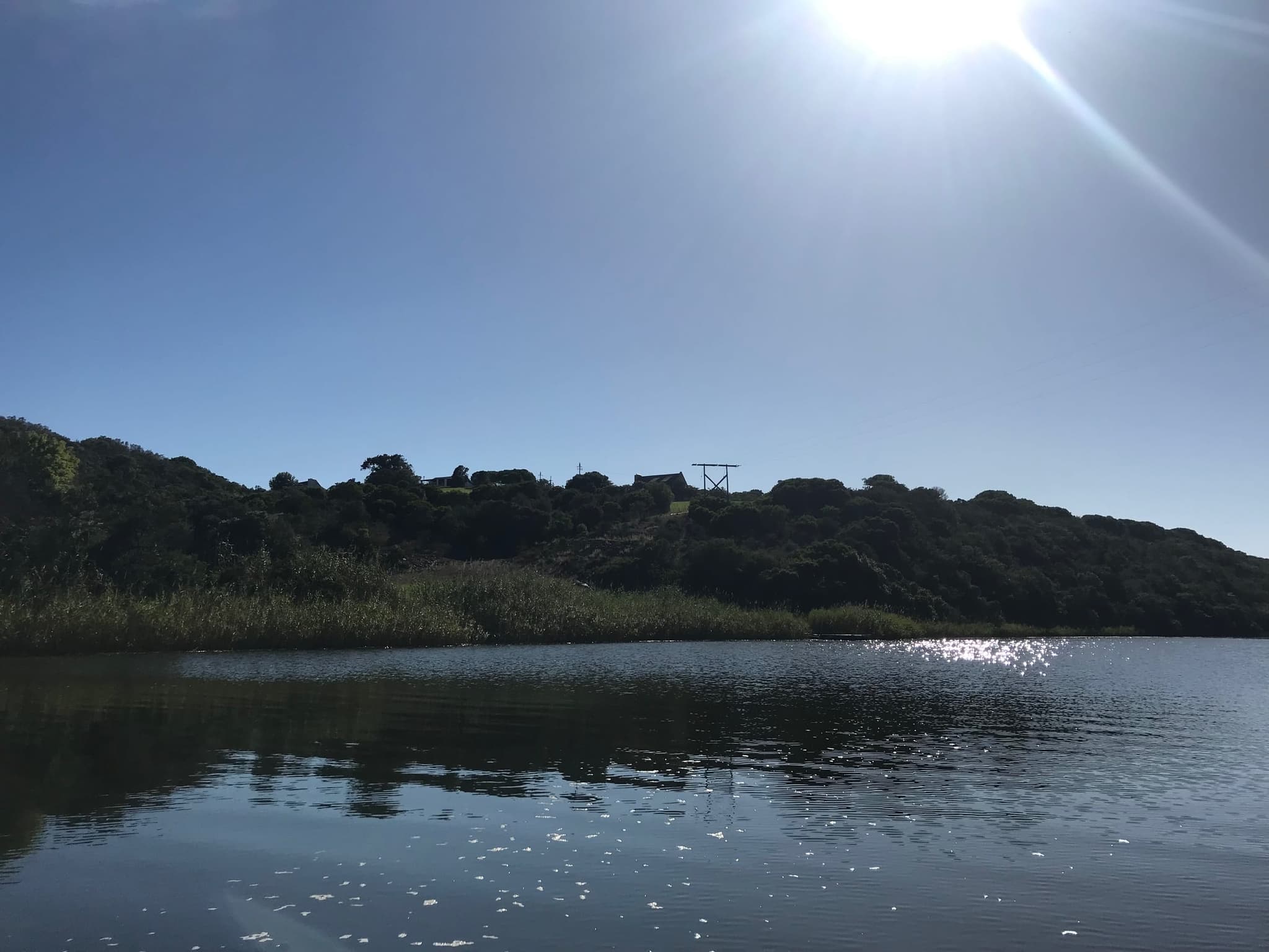Morning sun sparkling on the Goukou River, the wooded hills on the far bank.
