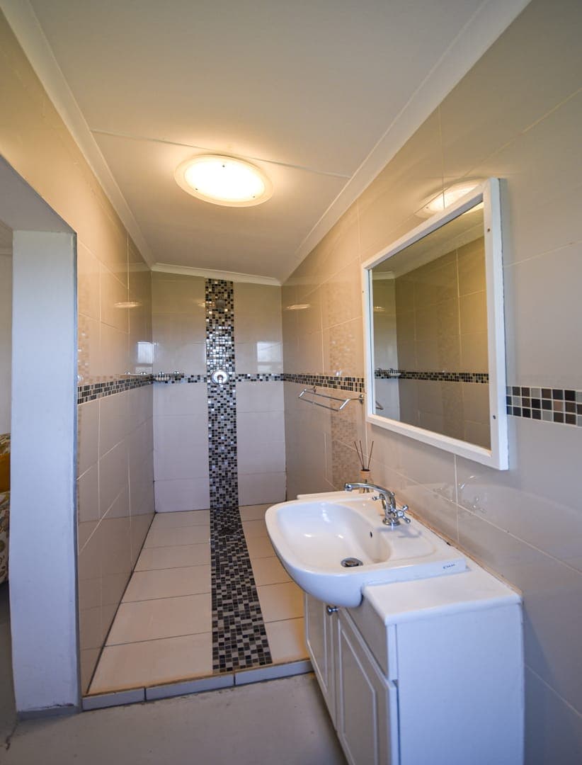 A tiled en-suite bathroom at White House Cottage with a walk-in shower.