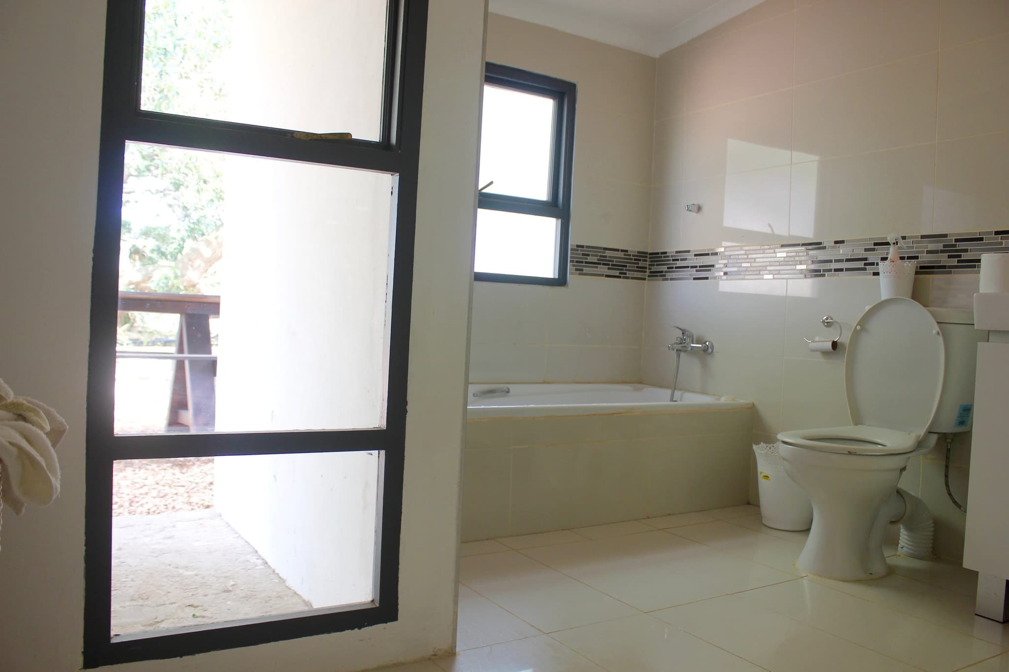 The master en-suite bathroom at White House Cottage, with a bath and a glass door to the veranda.