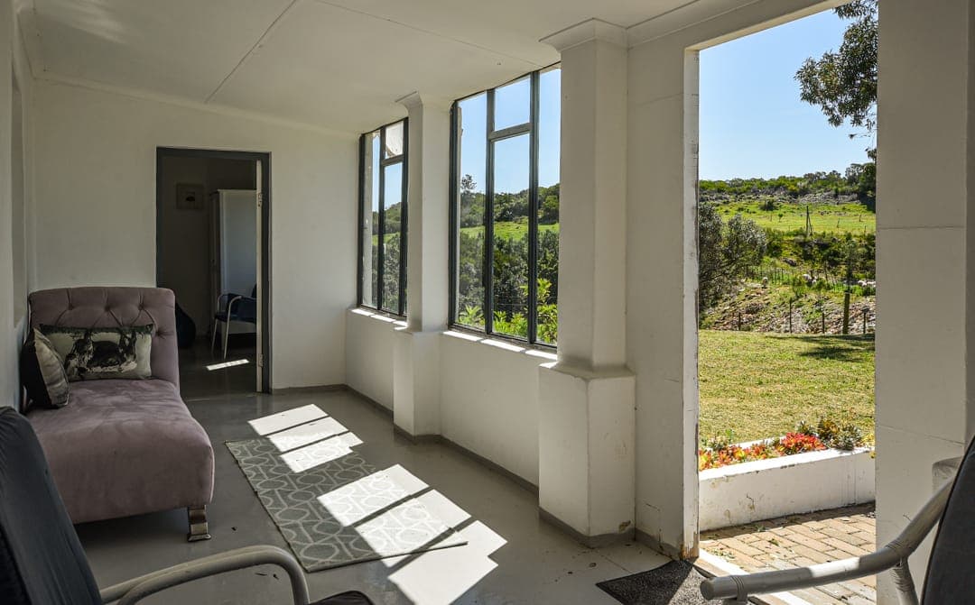 The sunroom at White House Cottage, with sun on the tiled floor and the door open to the garden.