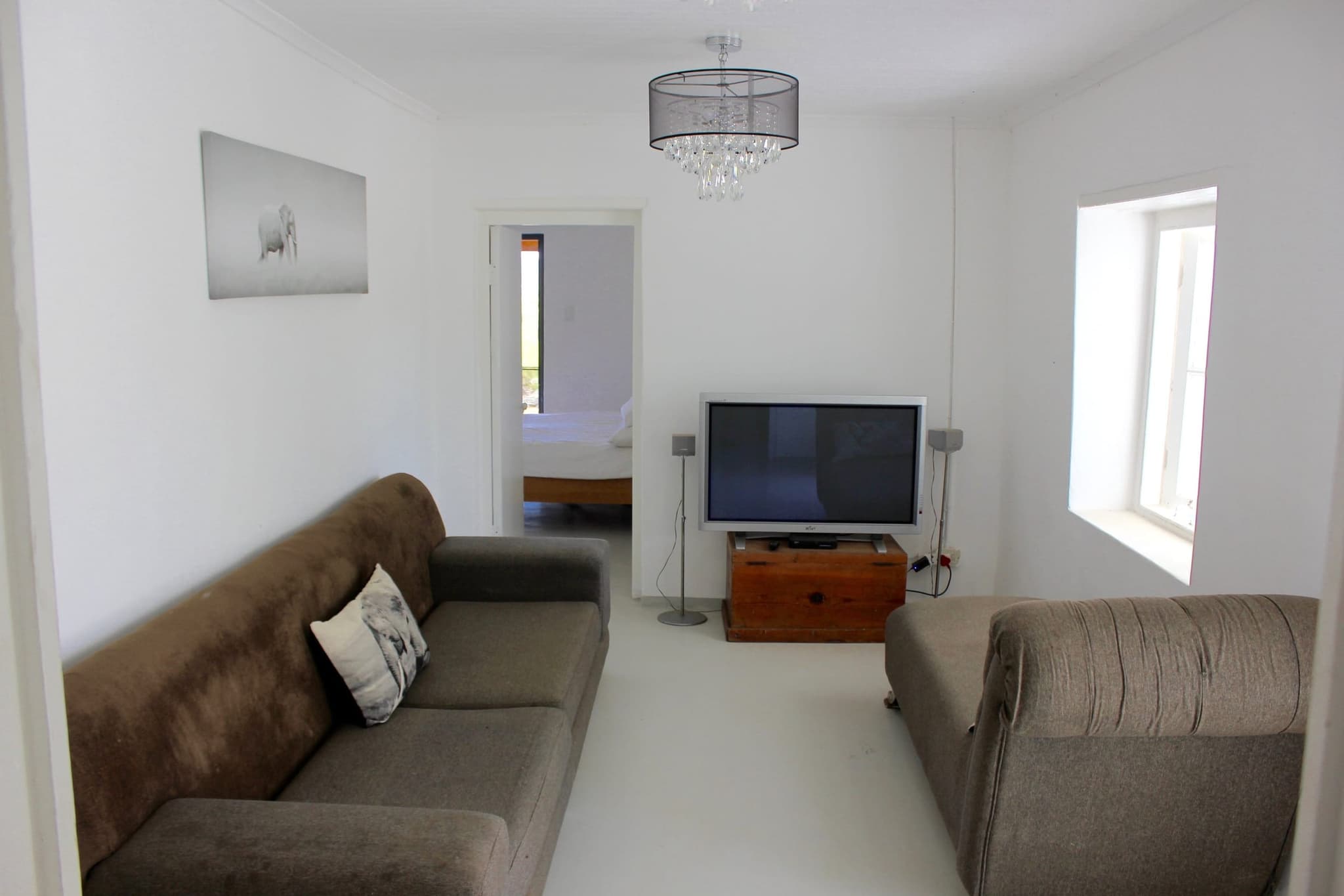 The TV room and lounge at White House Cottage, with two sofas and a flat-screen TV.