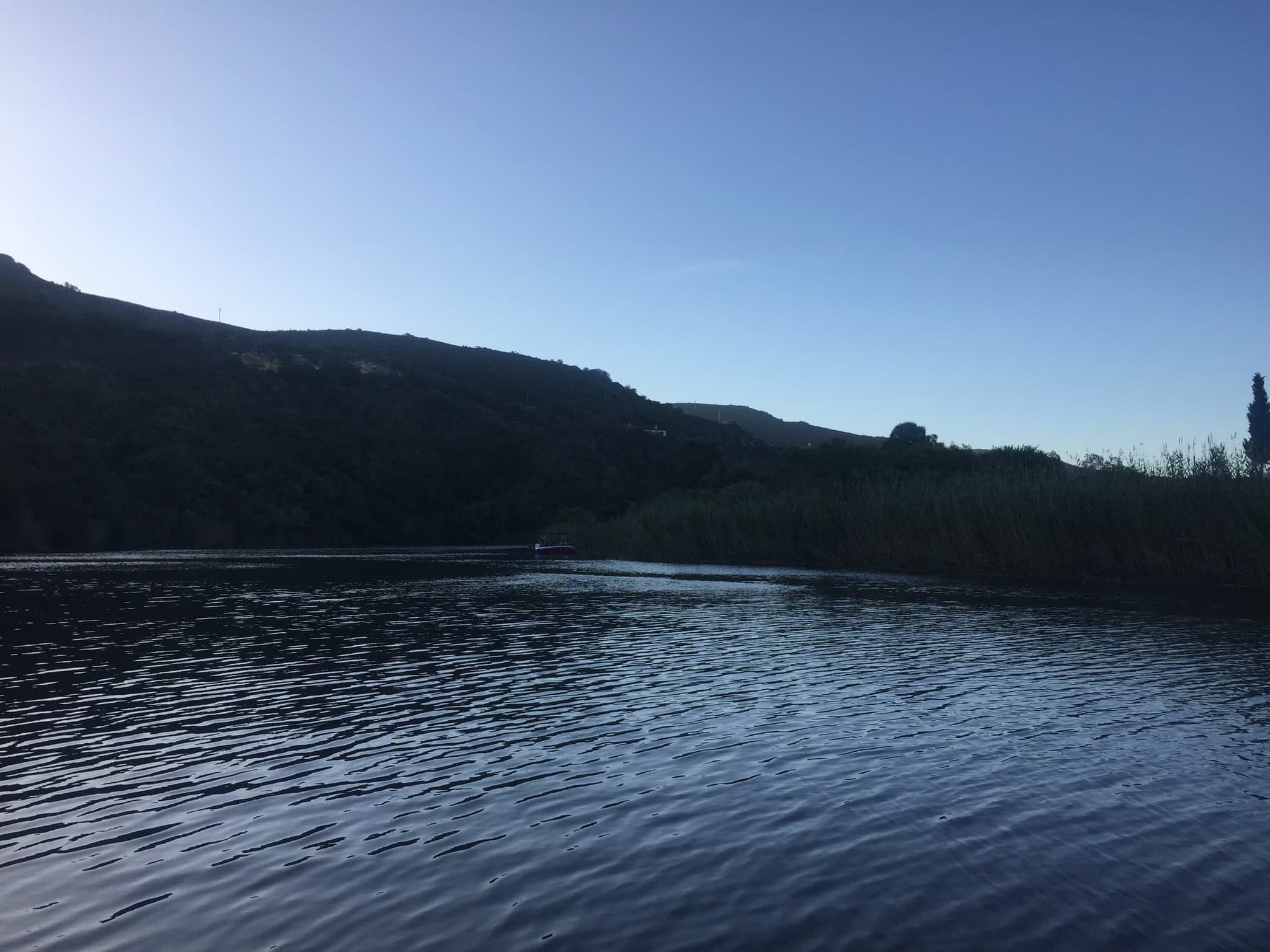 Dusk on the Goukou upriver, a wooded hill reflected in the water.